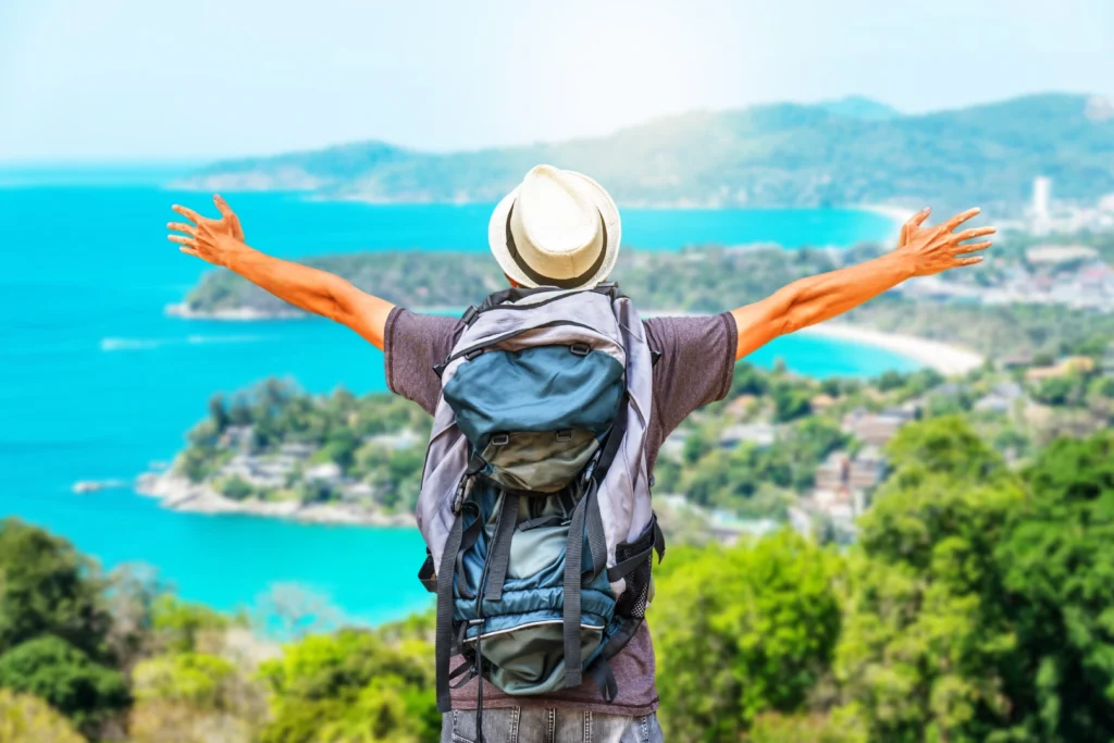 rear-view-portrait-young-man-traveler-with-backpack-standing-mountain-with-arms-spread
